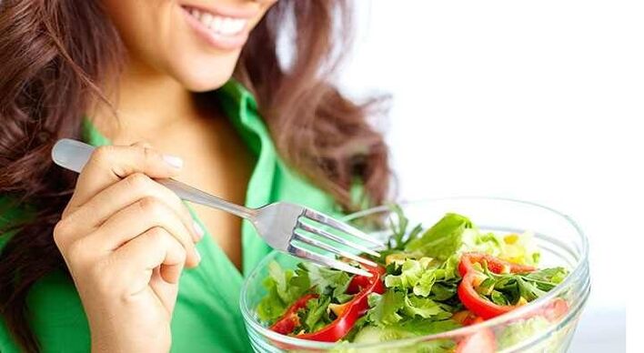 Ragazza che mangia insalata di verdure con una dieta proteica